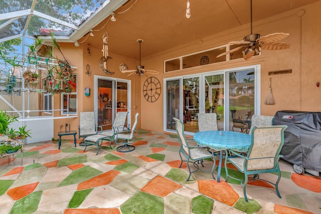 view of patio with glass enclosure, grilling area, and a ceiling fan