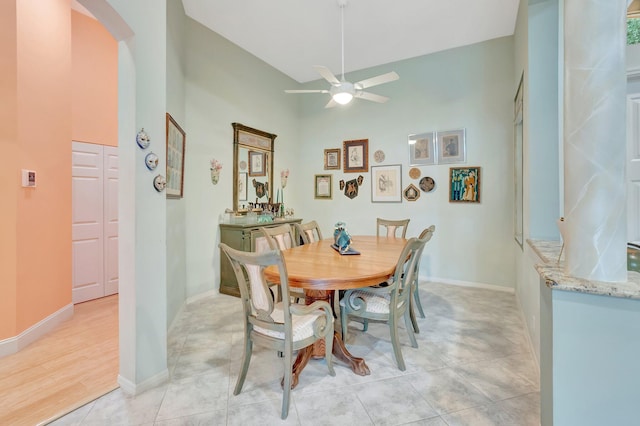 dining room with arched walkways, ceiling fan, and baseboards