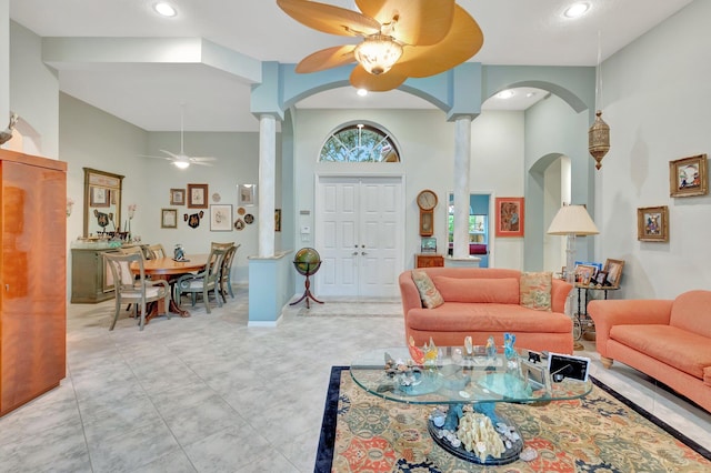 living area featuring a towering ceiling, ornate columns, a ceiling fan, and recessed lighting