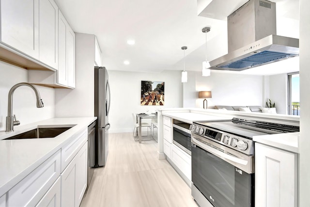 kitchen with stainless steel appliances, island exhaust hood, sink, and white cabinetry