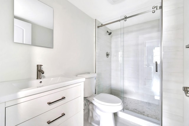 bathroom featuring vanity, toilet, and a shower with door