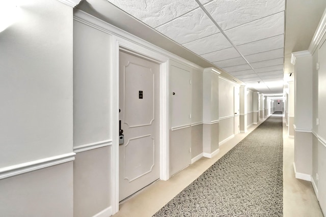 hall with crown molding and a paneled ceiling