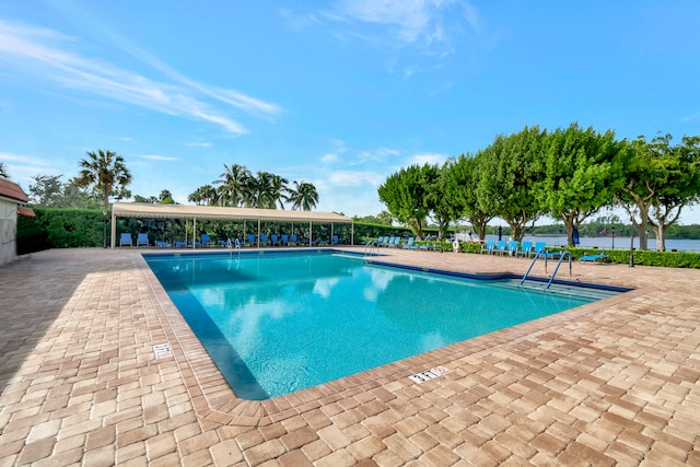 view of swimming pool with a patio and a water view