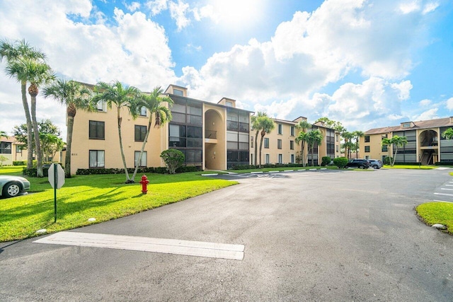 view of building exterior featuring a residential view and uncovered parking