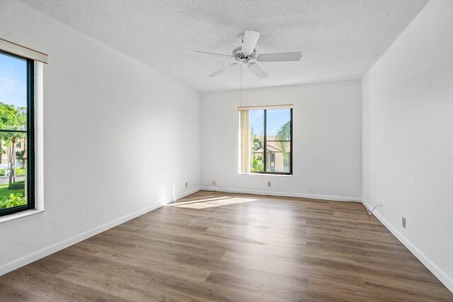 unfurnished room with ceiling fan, a textured ceiling, and hardwood / wood-style flooring