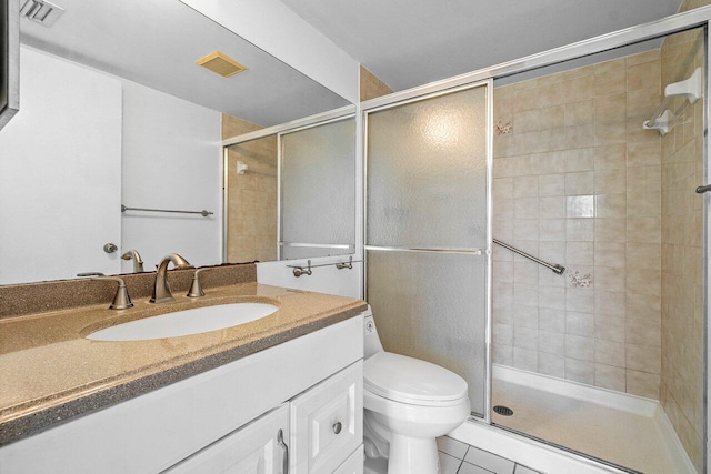 bathroom with a shower with shower door, vanity, toilet, and tile patterned flooring