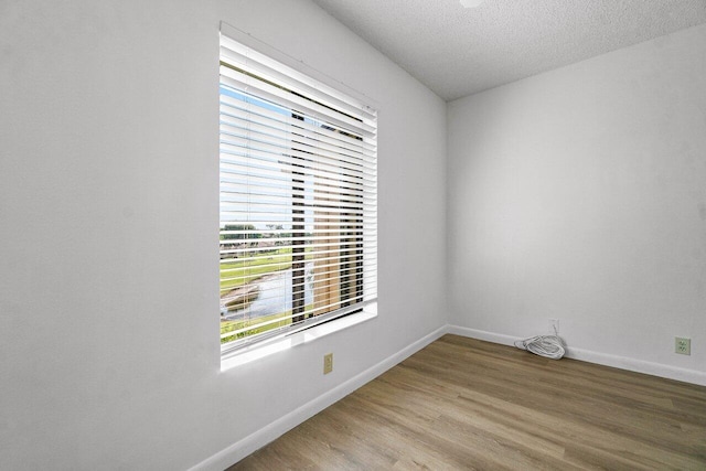 spare room featuring a textured ceiling and hardwood / wood-style floors