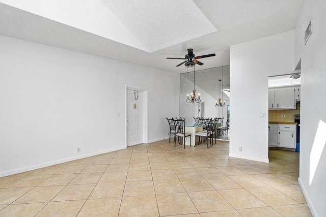 unfurnished dining area with ceiling fan with notable chandelier, a textured ceiling, light tile patterned flooring, and lofted ceiling