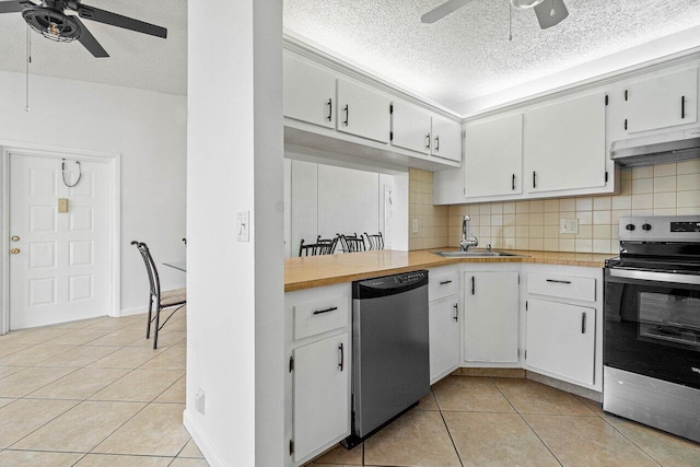 kitchen featuring ceiling fan, white cabinets, stainless steel appliances, and decorative backsplash