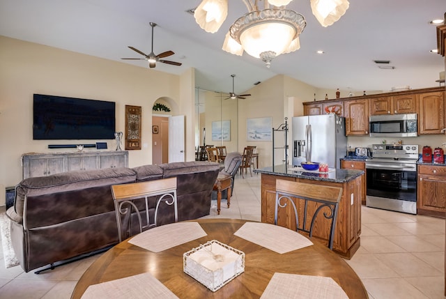 dining space featuring ceiling fan, vaulted ceiling, and light tile patterned floors