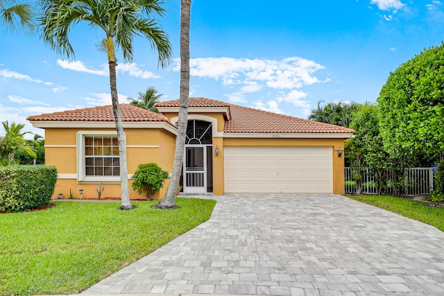 mediterranean / spanish house featuring a garage and a front yard