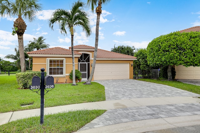 mediterranean / spanish home featuring a garage and a front lawn