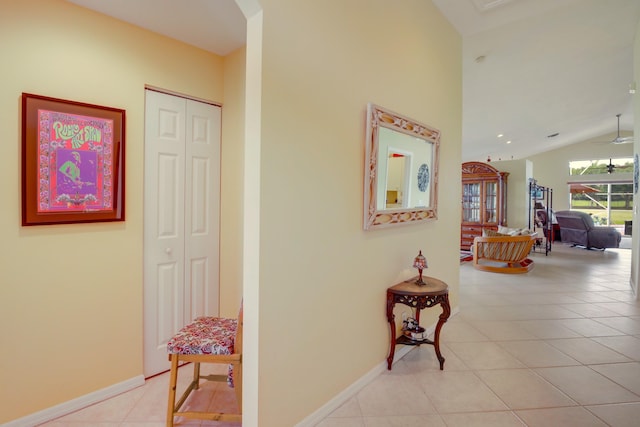 corridor featuring light tile patterned floors and vaulted ceiling