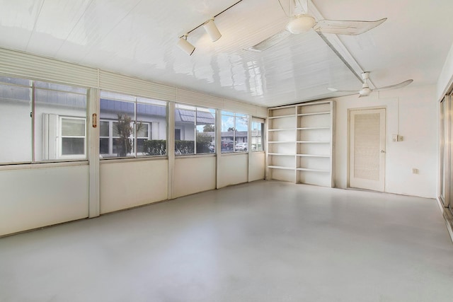 unfurnished sunroom with ceiling fan