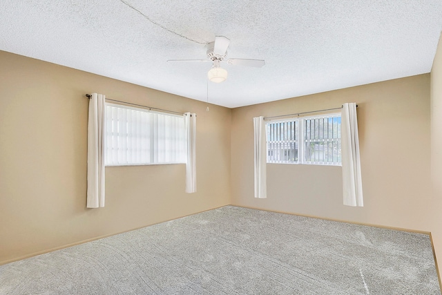 spare room with carpet flooring, ceiling fan, and a textured ceiling