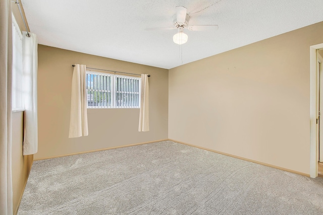 carpeted spare room with ceiling fan and a textured ceiling