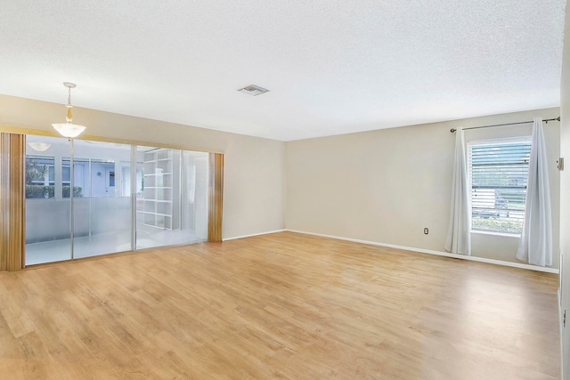 empty room featuring light hardwood / wood-style flooring and a textured ceiling