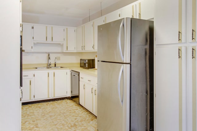 kitchen with stainless steel appliances, white cabinetry, and sink