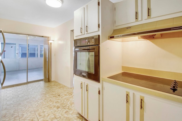 kitchen featuring light tile patterned floors, white cabinetry, and black appliances