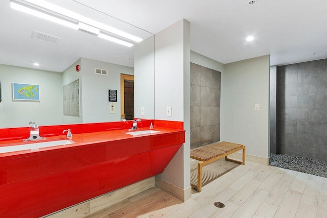 bathroom with walk in shower, wood-type flooring, and vanity