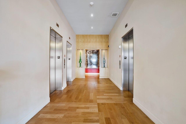 hallway featuring light hardwood / wood-style flooring and elevator