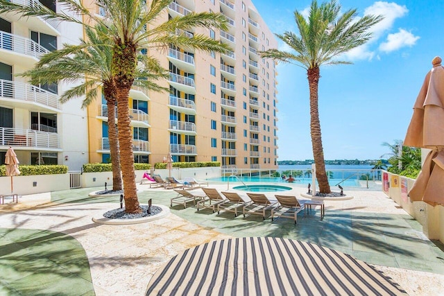 view of swimming pool with a water view and a patio area