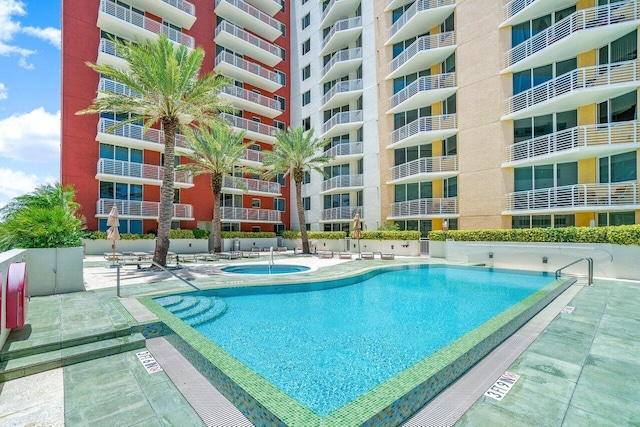 view of pool with a hot tub