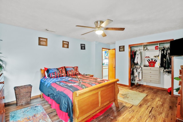 bedroom with a ceiling fan, a closet, visible vents, and wood finished floors