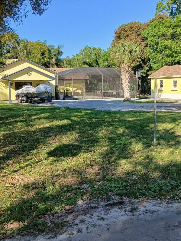 exterior space featuring glass enclosure and a front yard