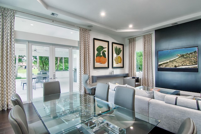 dining space with hardwood / wood-style flooring, french doors, and a tray ceiling