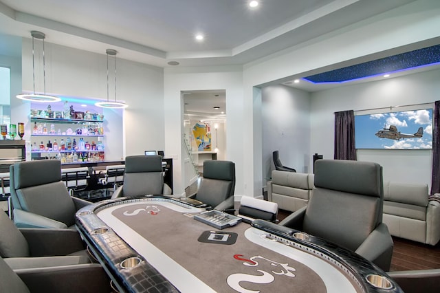 game room featuring a tray ceiling and wood-type flooring