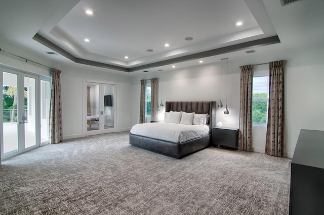 carpeted bedroom featuring a tray ceiling, access to outside, and french doors