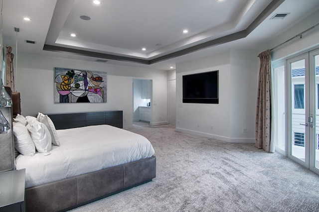 bedroom featuring light colored carpet, french doors, access to outside, and a tray ceiling