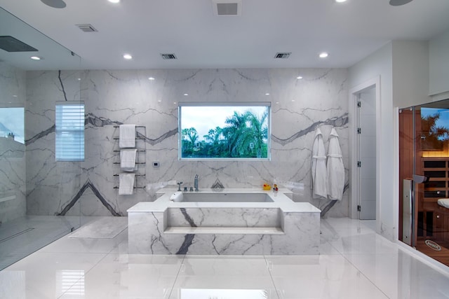 bathroom featuring tile walls and shower with separate bathtub