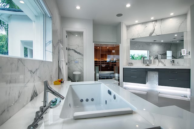 bathroom featuring vanity, a bathtub, toilet, and tile walls