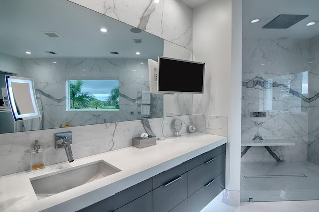 bathroom with a shower, vanity, and tile walls