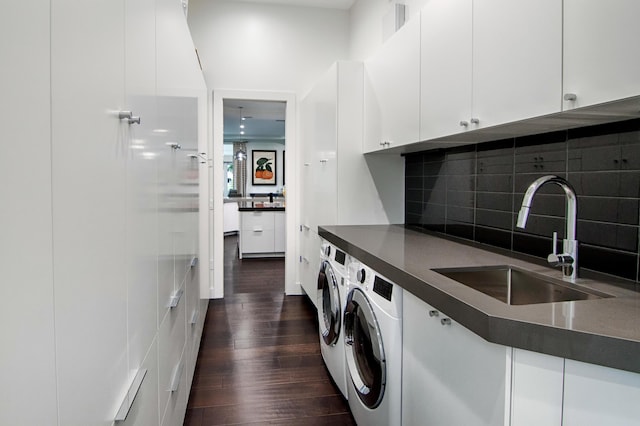 washroom with cabinets, dark hardwood / wood-style floors, washer and clothes dryer, and sink