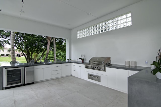 view of patio with area for grilling, exterior kitchen, sink, and beverage cooler