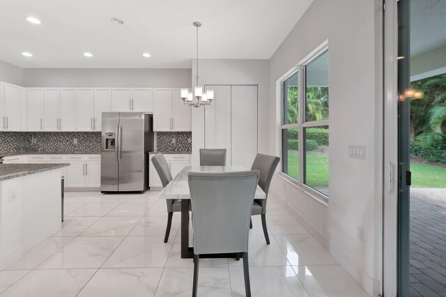 dining area with light tile patterned flooring, a chandelier, and a healthy amount of sunlight