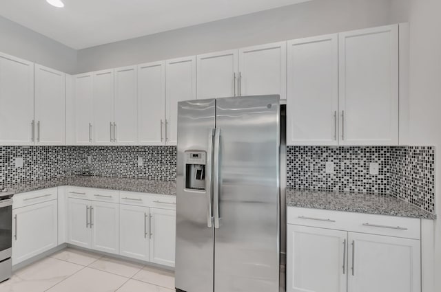 kitchen with stainless steel refrigerator with ice dispenser, light tile patterned floors, decorative backsplash, white cabinetry, and stone counters