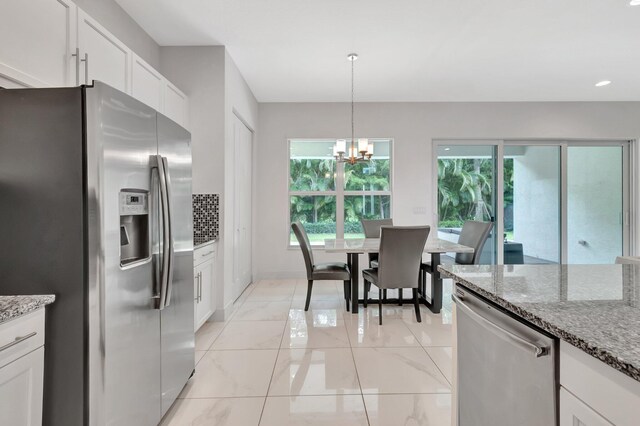 kitchen with light tile patterned floors, stainless steel appliances, plenty of natural light, and white cabinetry