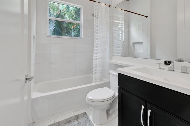 full bathroom with toilet, shower / bath combo with shower curtain, vanity, and tile patterned flooring