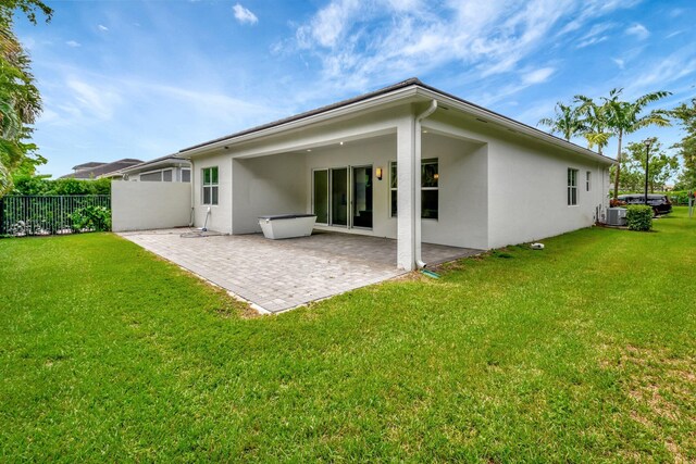 rear view of house featuring a patio, central AC unit, and a yard