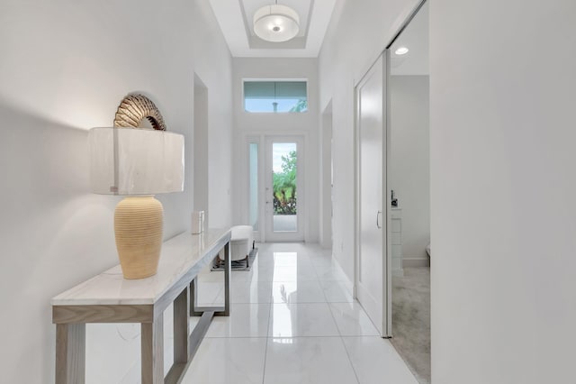 interior space featuring a towering ceiling and light tile patterned floors