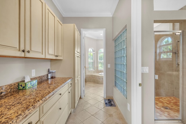 kitchen with light tile patterned flooring, light stone counters, crown molding, and cream cabinets