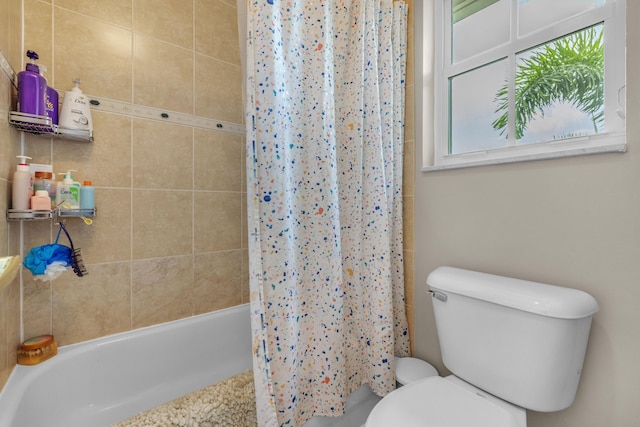 bathroom featuring toilet and shower / bathtub combination with curtain