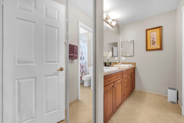 9229 Delemar Ct, Wellington, FL 33414 - full bathroom featuring a textured ceiling, double vanity, toilet, tile patterned flooring, and baseboards