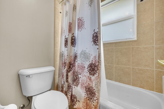 bathroom with shower / bathtub combination with curtain and toilet