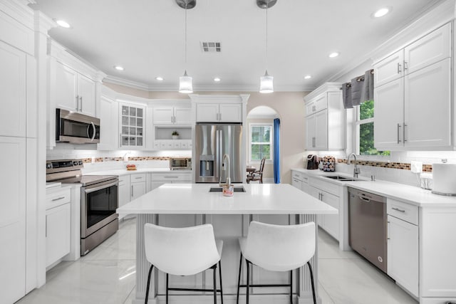 9229 Delemar Ct, Wellington, FL 33414 - kitchen with stainless steel appliances, a sink, arched walkways, backsplash, and ornamental molding