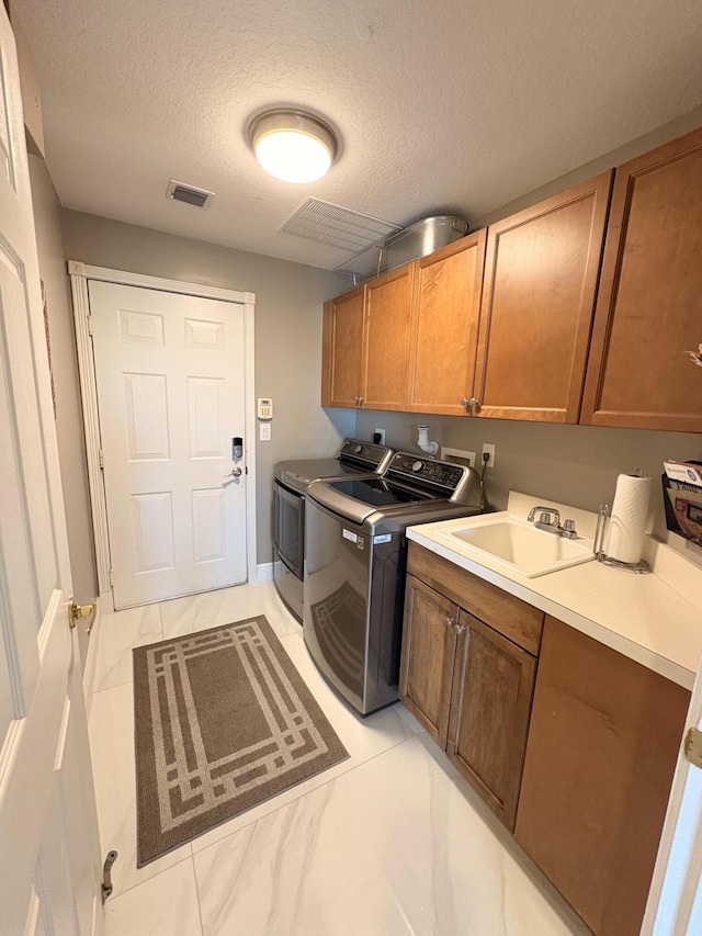 9229 Delemar Ct, Wellington, FL 33414 - laundry area featuring cabinet space, separate washer and dryer, a textured ceiling, and baseboards